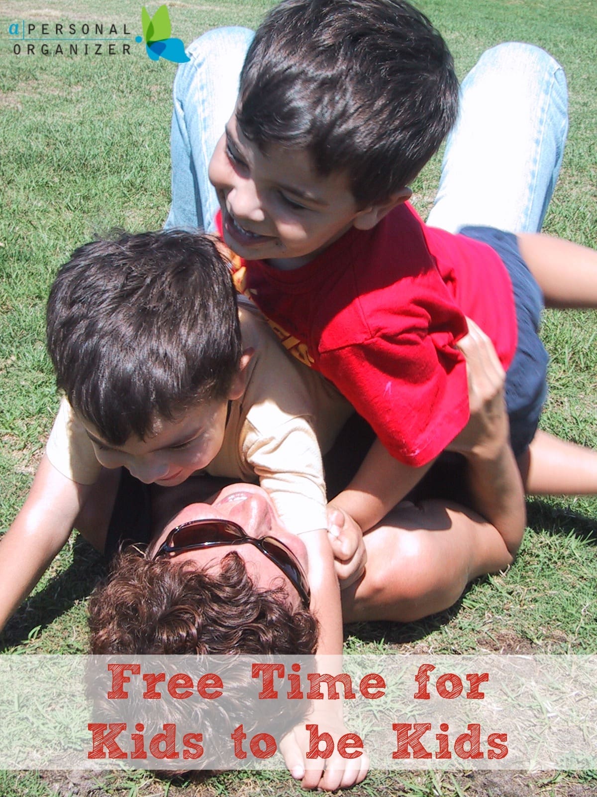 A woman lying on grass playfully hugs and laughs with two young boys climbing on her, embodying the joy of free time for kids. The image features the text: "Free Time for Kids to be Kids.
