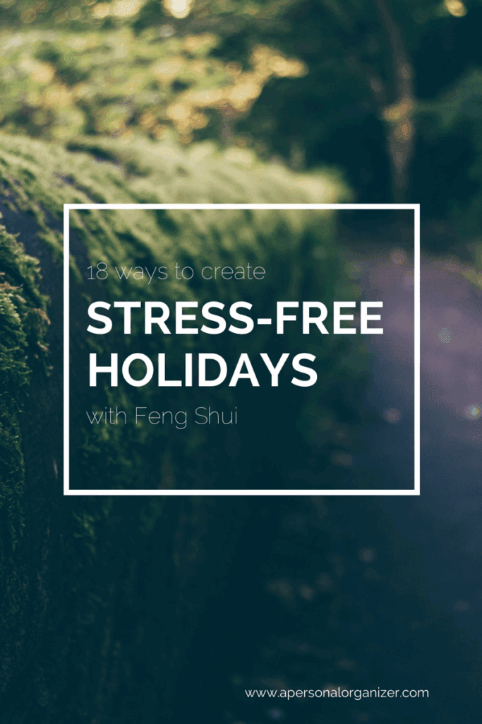 A blurred forest path with lush greenery and moss-covered stones. White text overlay reads: "13 ways to create STRESS-FREE HOLIDAYS with Feng Shui." Discover tips for truly stress free holidays at apersonalorganizer.com.
