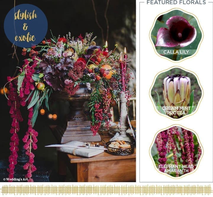 Floral arrangement with vibrant red, purple, and green blooms, featuring calla lilies, cream mint proteas, and elephant head amaranths on a wooden pedestal—perfect for a Thanksgiving table. Two lit candles and a small dish of white flowers are nearby. Text reads "stylish & exotic.