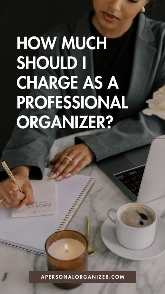 A person in business attire writes in a notebook at a desk with a laptop, coffee, and candle. Text on image reads: "How much should I charge as an organizing professional?" Perfect for those who want to help others declutter and find organization.