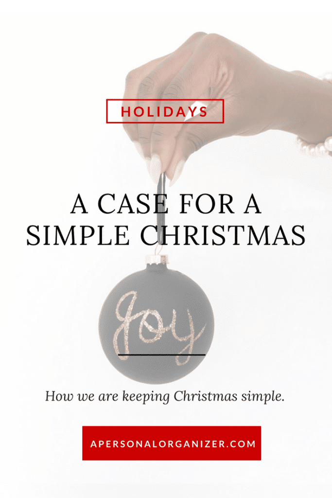 A hand holding a black Christmas ornament with "joy" written on it in gold. The text reads, "HOLIDAYS A Case for a Simple Christmas. How we are keeping a simple Christmas." At the bottom, a website URL: apersonalorganizer.com.