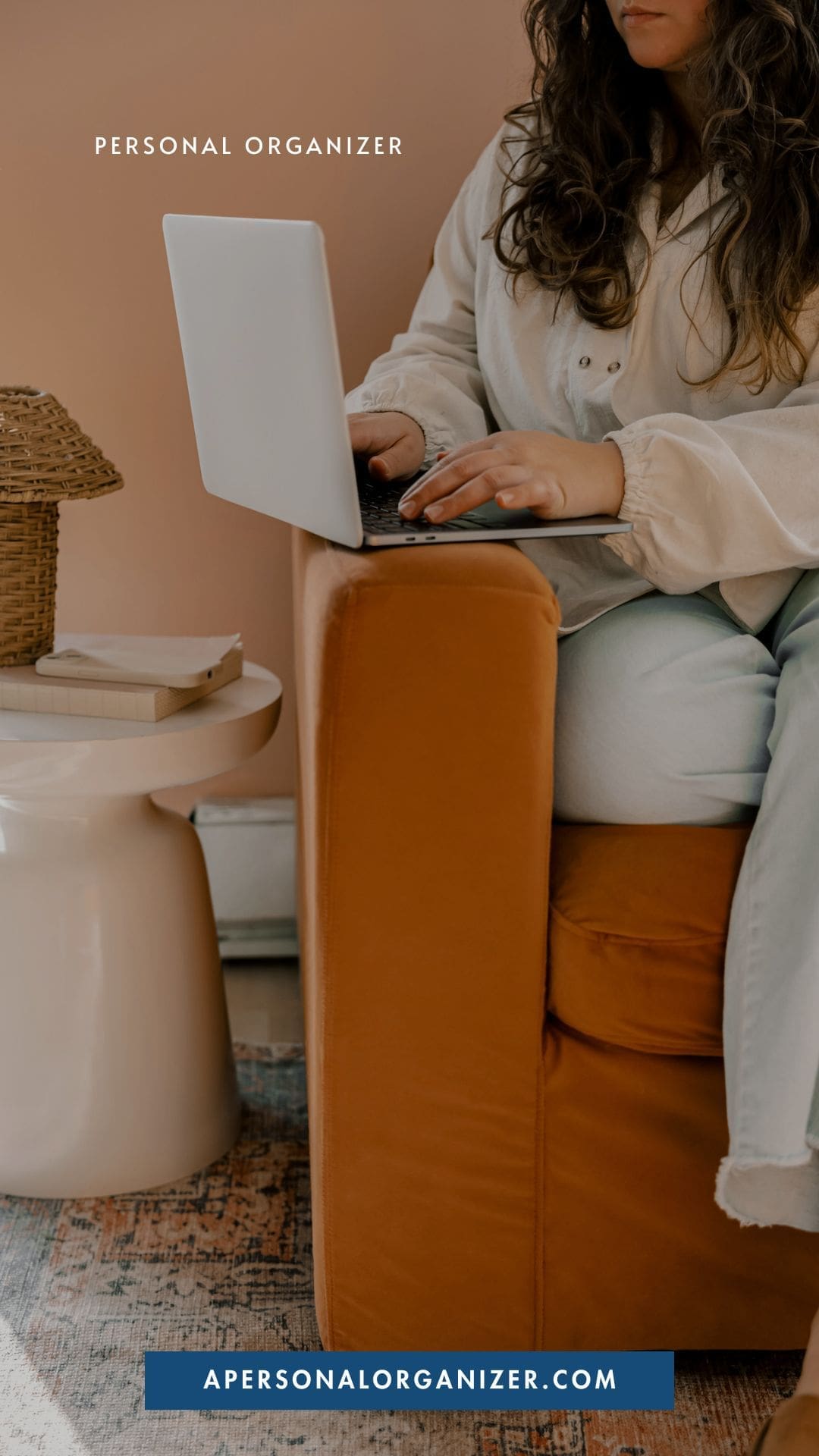 A woman sits on an orange chair using a laptop on her lap. Nearby, a small table holds books and a woven lamp—perfect for inspiring you to declutter your space. Text reads "Personal Organizer" and "apersonalorganizer.com.