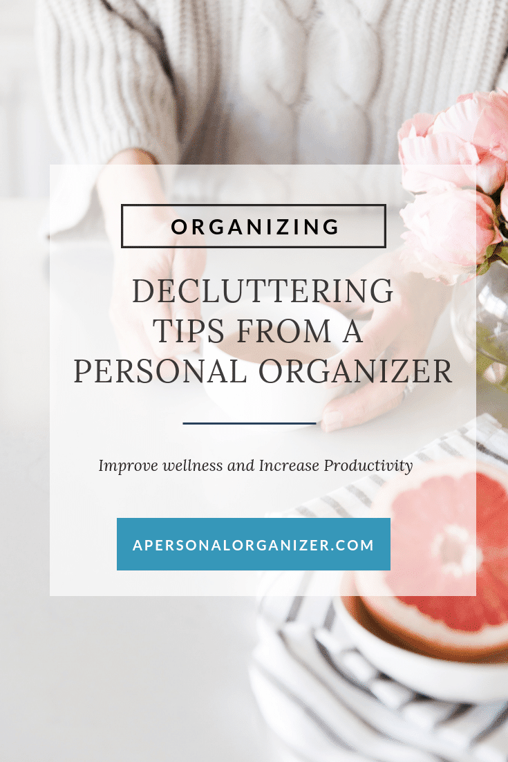 A poster titled "Decluttering Tips from a Personal Organizer" with a subheading "Improve Wellness and Increase Productivity." The background shows a person organizing items on a table with pink flowers and a grapefruit. For more decluttering tips, visit APERSONALORGANIZER.COM.