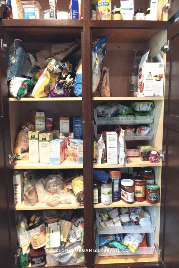 A cluttered kitchen pantry with shelves filled haphazardly with food items, boxes, jars, cans, bags, and containers. Some sections look disorganized—making it clear it’s time to organizar a despensa for a tidier space.
