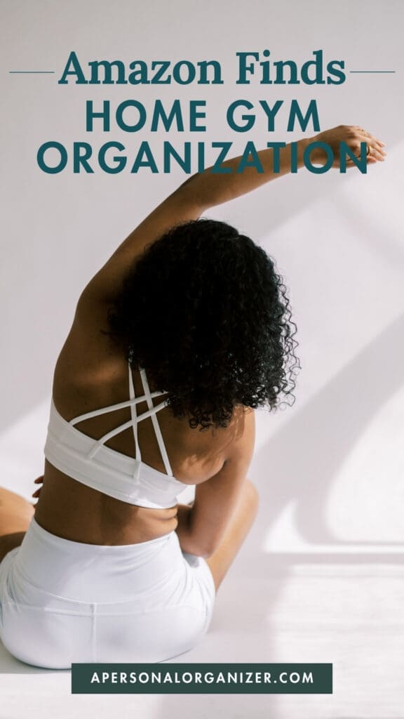 A woman in white athletic wear stretches on the floor under sunlight. Text above reads "Amazon Essentials Home Gym Organization" and a website, apersonalorganizer.com, is displayed below.
