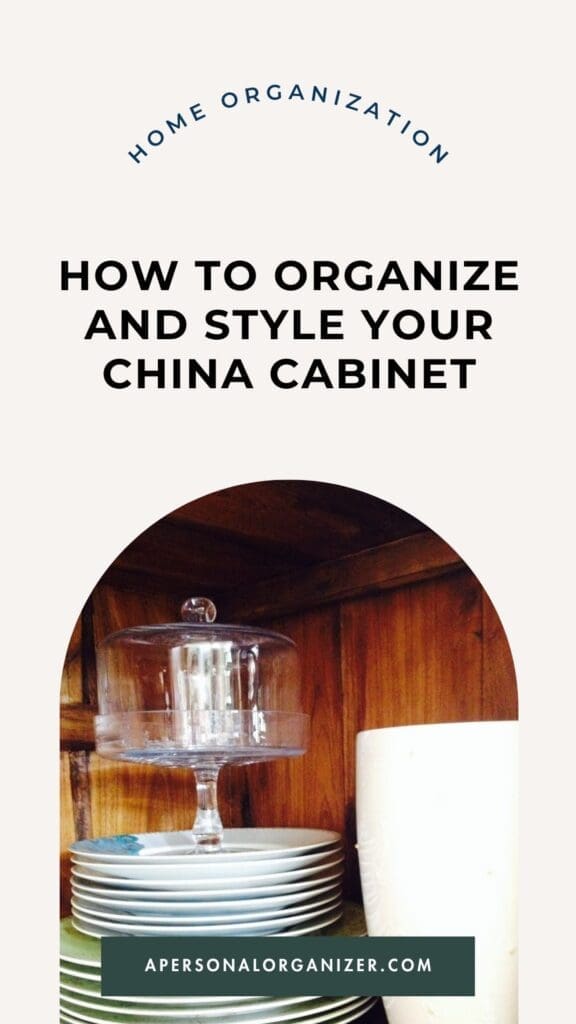A neatly organized china cabinet with stacked plates, a glass cake stand, white dishware, and the text "How to Organize and Style Your China Cabinet" and "apersonalorganizer.com.