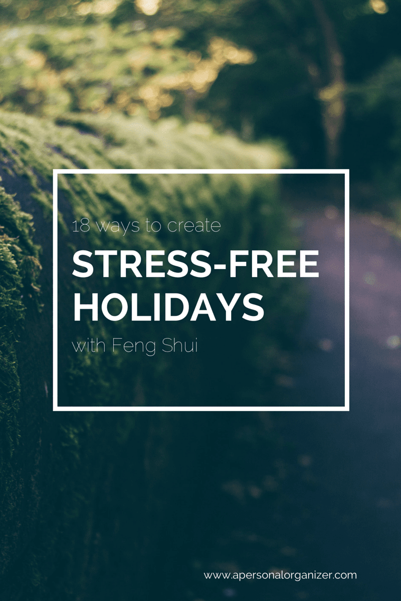 A blurred forest path with lush greenery and moss-covered stones. White text overlay reads: "13 ways to create STRESS-FREE HOLIDAYS with Feng Shui." Discover tips for truly stress free holidays at apersonalorganizer.com.