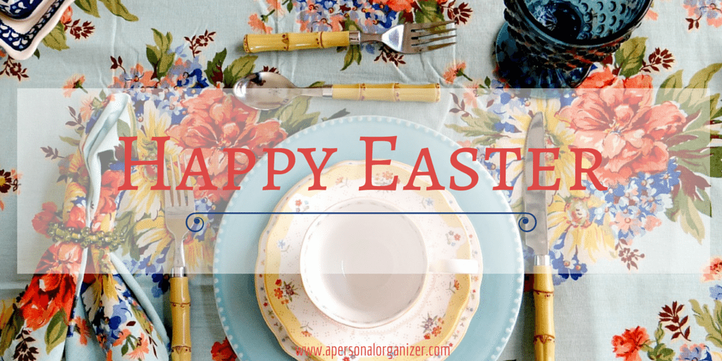 A colorful Easter table setting with a floral-patterned cloth, blue plate, floral napkin, and a teacup is beautifully arranged. The words "Happy Easter" are prominently displayed in red over the image, perfectly complementing the festive ambiance with timeless Easter quotes.