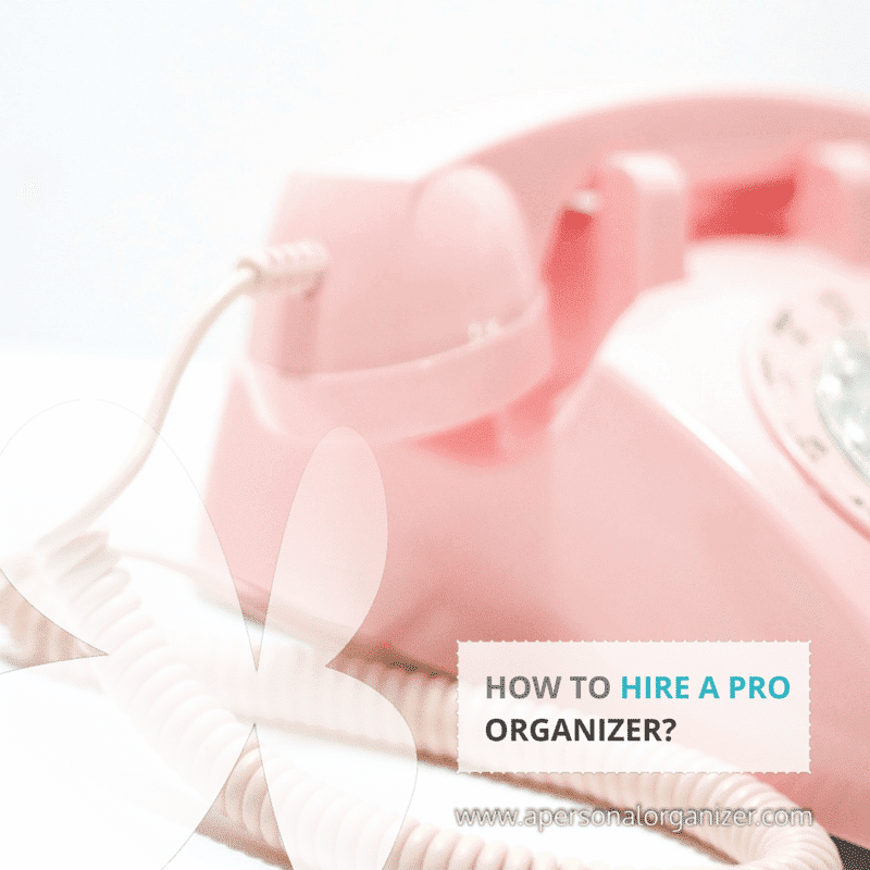A close-up photo of a pink rotary telephone with a cord loosely coiled at the base. Overlaid text in the lower right corner reads, "HOW TO HIRE A PRO ORGANIZER?" and the website "www.apersonalorganizer.com" is visible. Discover how to find your perfect professional organizer today!