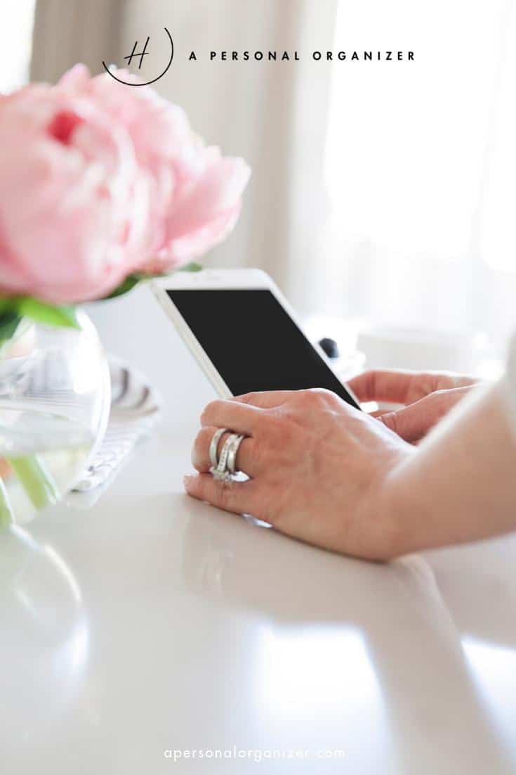 Hands holding a tablet on a white table next to a vase with pink flowers. The scene exudes calm and minimalism, ideal for those seeking help organizing their personal tasks. The text "A Personal Organizer" graces the top, emphasizing efficient productivity.