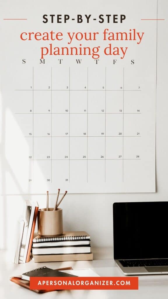 A minimalist desk setup features a calendar on the wall, primed for your family planning day. The calendar awaits important dates, while stacked books, a laptop, and a container of pencils await your creativity. Text reads, "Step-by-step create your family planning day.
